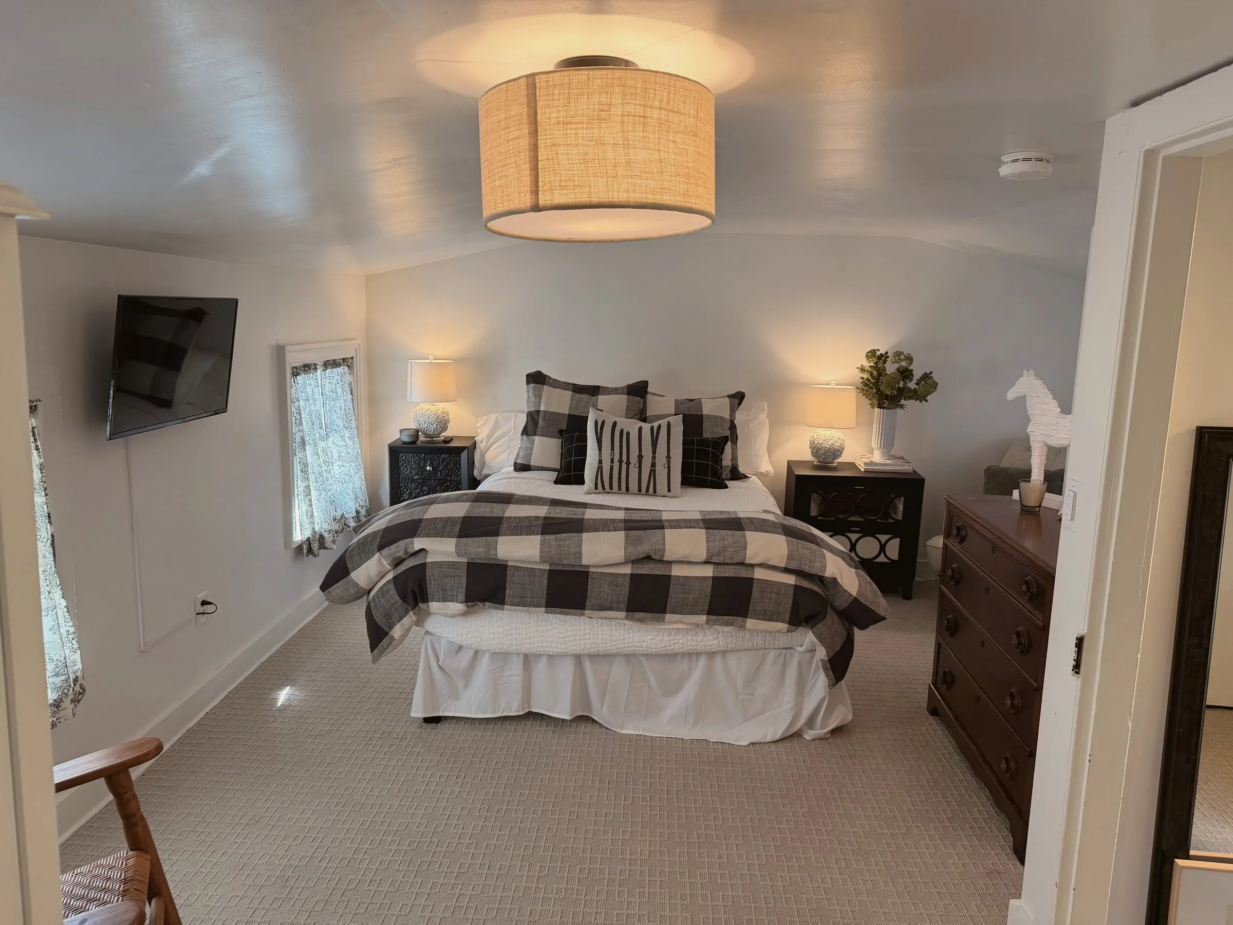The queen over the den — buffalo-check quilt, en-suite bath