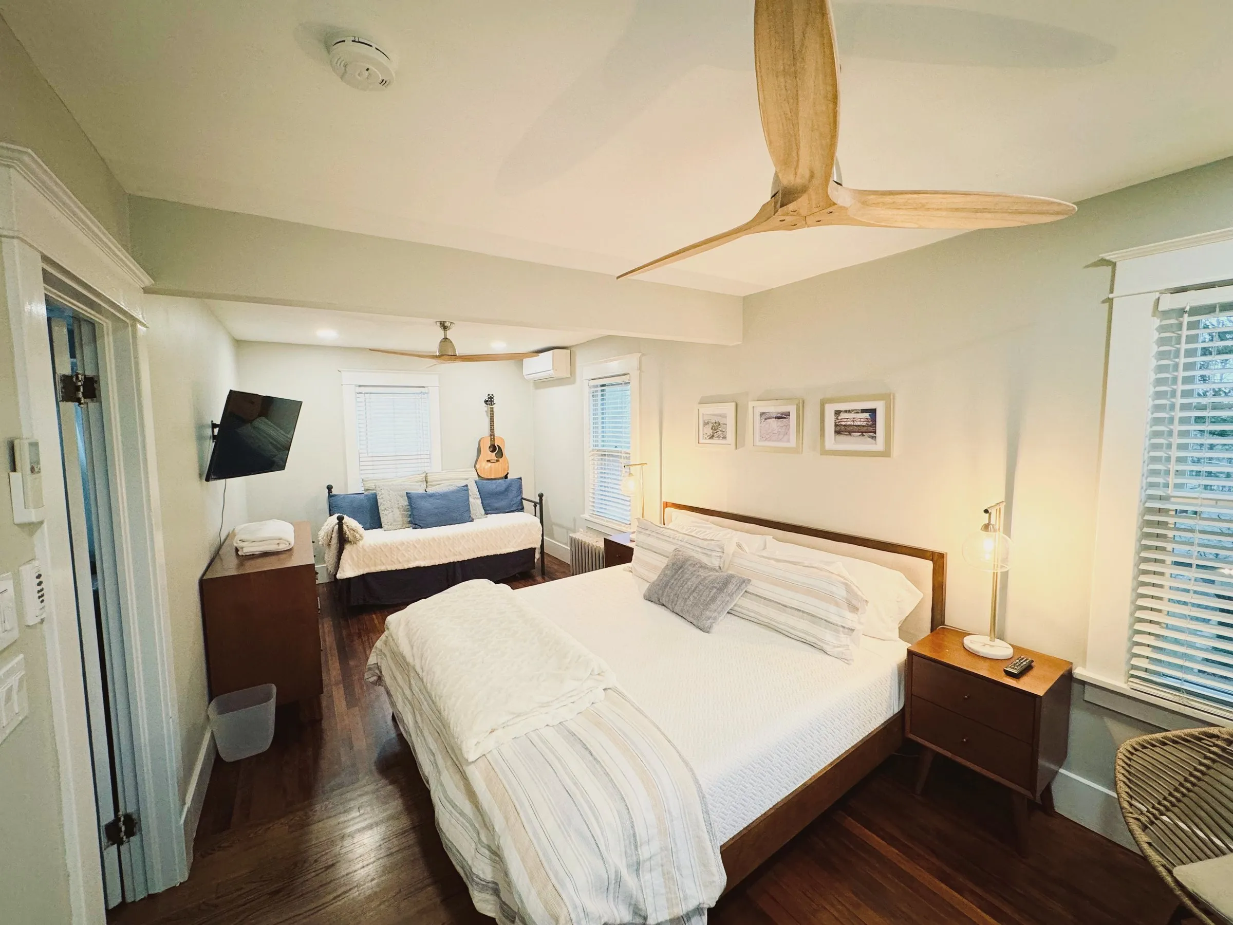 The carriage house bedroom — king bed, guitar in the corner