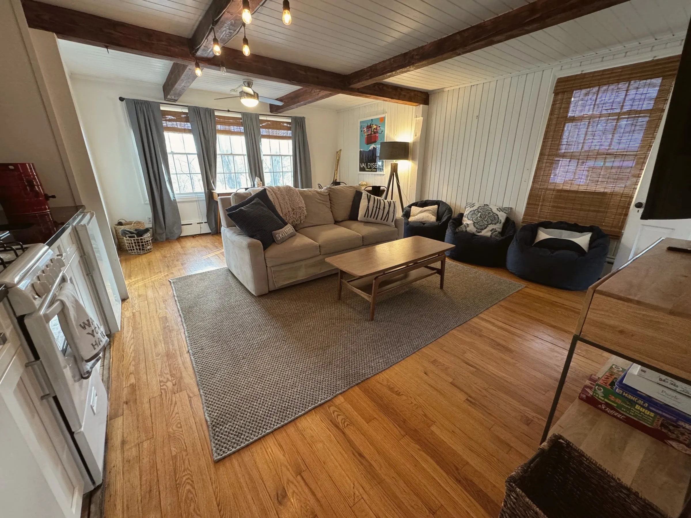 The den under hand-hewn beams — games, second kitchen, big TV