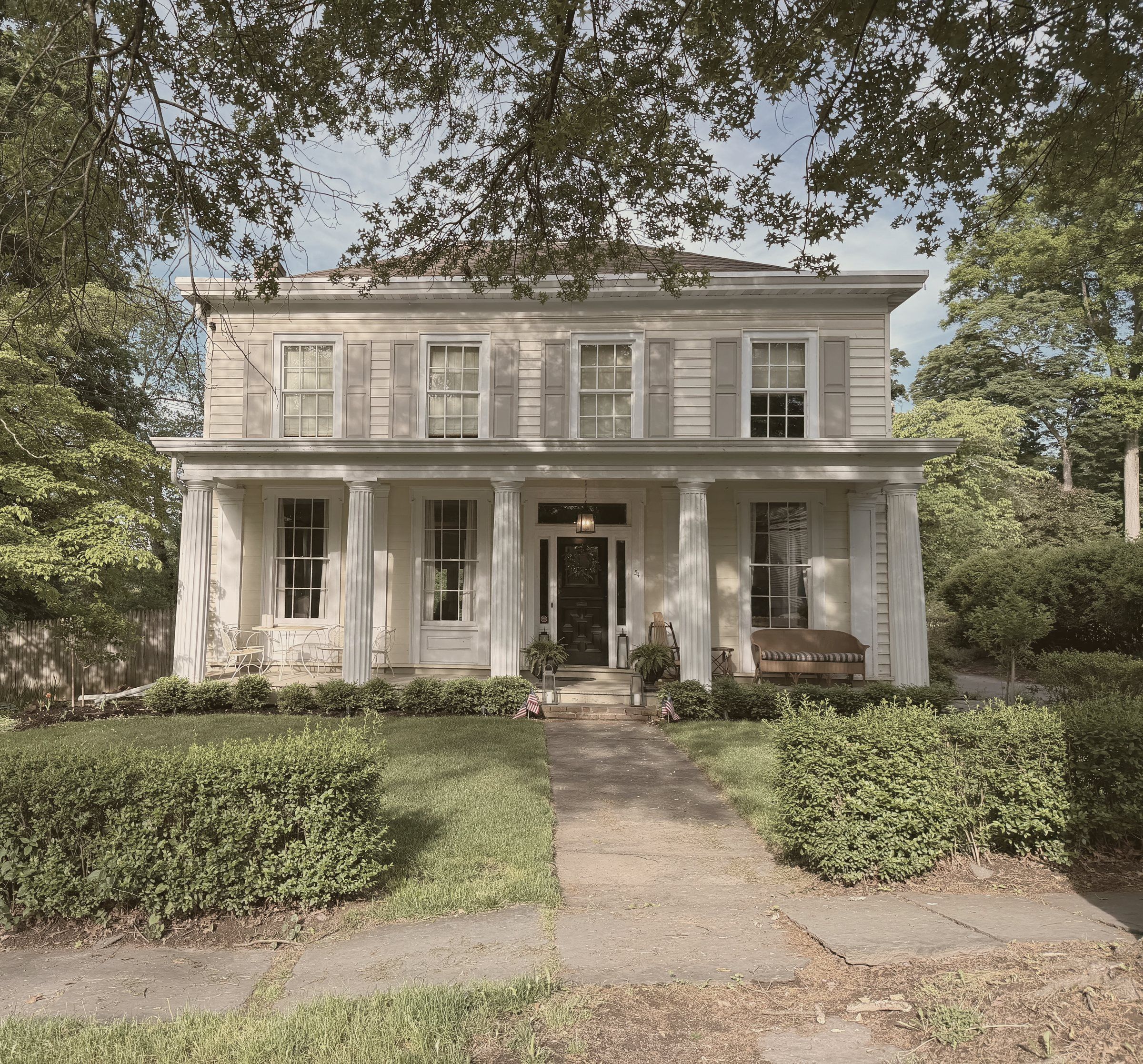 The 1844 House — a Greek Revival with fluted columns behind boxwood hedges, Saugerties, New York