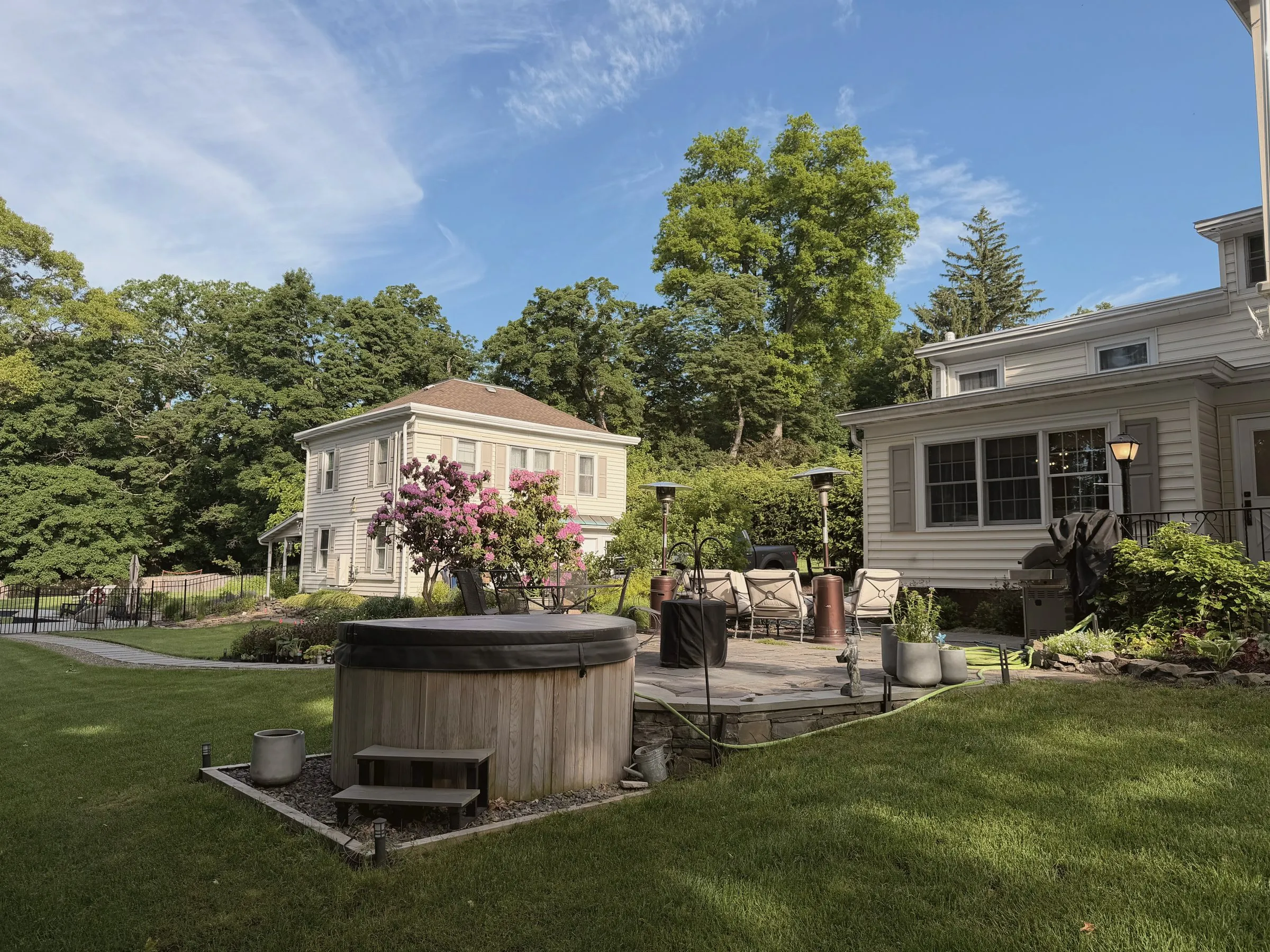 The six-person cedar hot tub on the stone patio