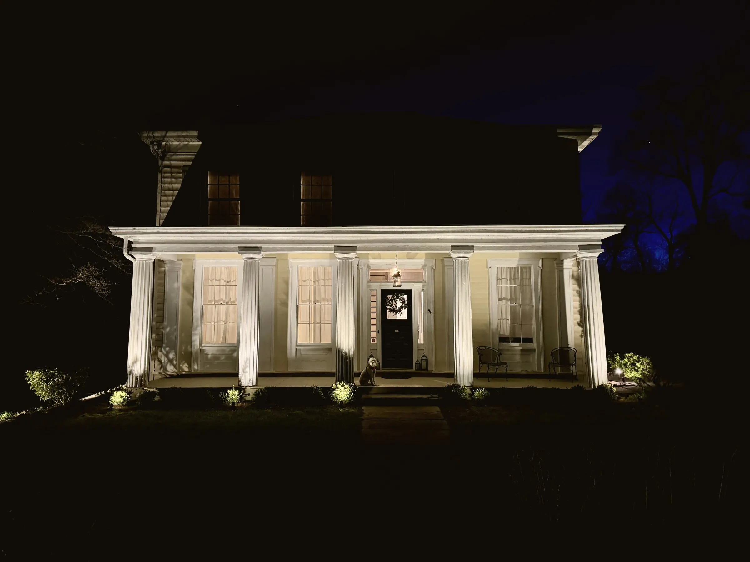 The portico lit at night, columns glowing against the dark